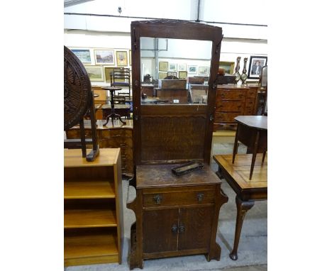 An oak hallstand with mirror flanked by two sets of three hooks over glove drawer and double cupboards and side stick stands,