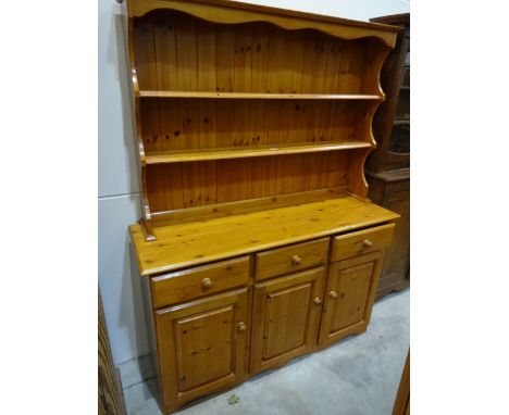 A pine kitchen dresser with triple cupboard base with drawers over and two shelf raised plate rack, 137cm x 44cm x 180cm high