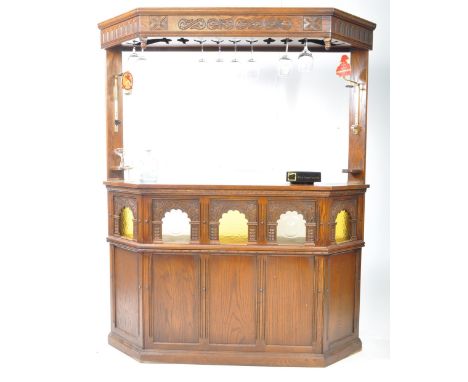 A mid 20th century Jaycee Jacobean oak bar in the colonial style. The bar, of angled form having a raised canopy with upright