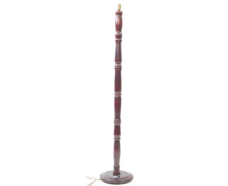 A vintage 20th century faux rosewood floor standing standard lamp. The lamp raised on small bun feet under a rounded base. Ha