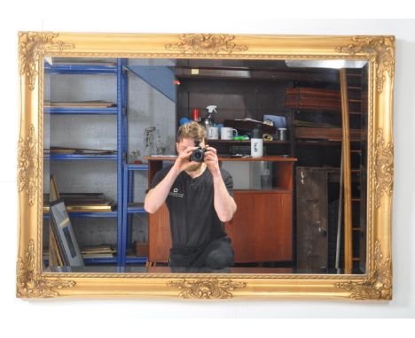 A large regency reproduction gilt wall hanging over mantel mirror. Rectangular form with central bevelled edge glass plate wi