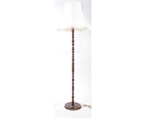 A vintage 20th century mahogany turned standard lamp. The lamp having rounded base, with turned column. Featuring white shade