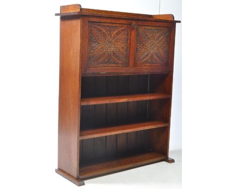 A late 19th century Arts &amp; Crafts style oak student bureau bookcase desk. The bookcase raised on block feet, having a ser