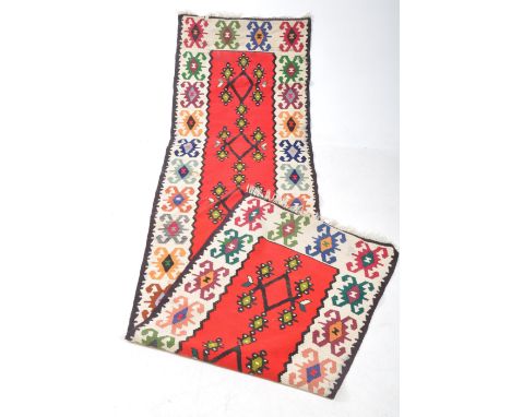 A contemporary Anatolian Turkish Kilim floor carpet runner rug. The runner having a central red panel with five rhombus shape