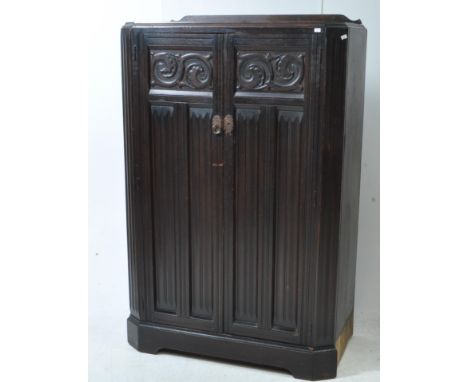 An early 20th century Arts &amp; Crafts carved oak compactum wardrobe. The compactum raised on a plinth base. Featuring two d