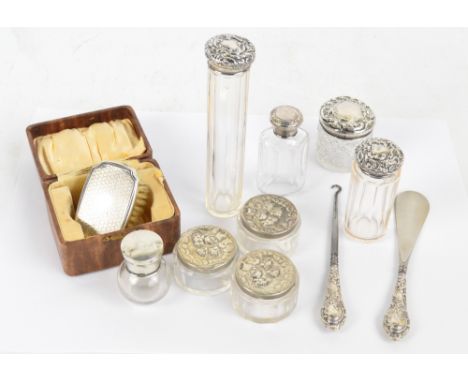 A group of seven various hallmarked silver topped dressing able jars, including a set of three with embossed cherubic motifs,