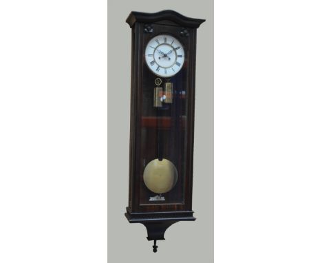 A late 19th century simulated rosewood twin weight Vienna wall clock, with curved pediment and applied flower head decoration