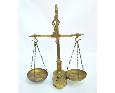 A brass beam scale by Libra & Co with shaped base with inset brass weights, height 55cm.