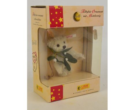 A boxed Steiff 2005 small teddy bear, no.037618 with numbered white and red tag to ear, with light grey fur and mistletoe, 65