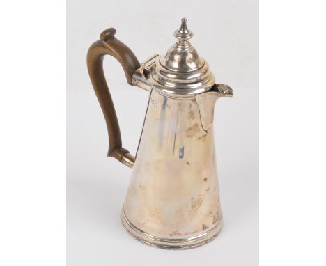A late Victorian hallmarked silver hot water jug of tapering form with domed hinged lid and cast finial, with scroll decorate