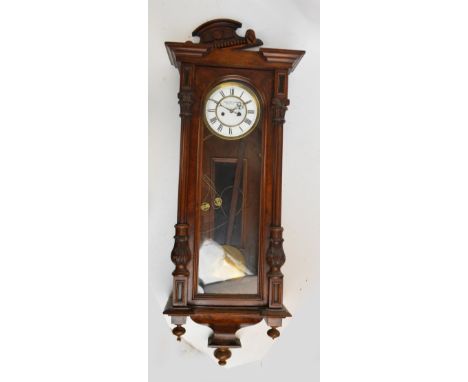 A late 19th century walnut Vienna style twin weight wall clock with white enamel dial inscribed "Vargyas Jzidor Szombathely",