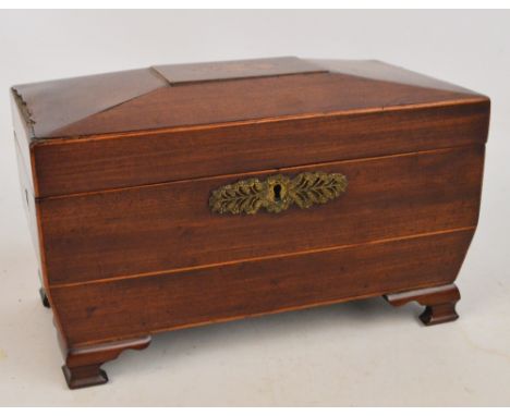 An early 19th century mahogany sarcophagus shaped tea caddy with inlay of flowers to the top and floral metal escutcheon rais