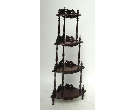 A reproduction carved mahogany bowfront four tier whatnot decorated with floral motifs, height 143cm including finial, width 