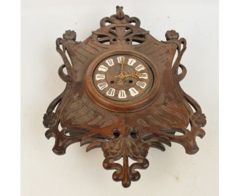 An early 20th century Art Nouveau mahogany cased wall clock with stylised floral decoration and enamel Roman numerals to the 