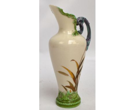 A large Royal Worcester ivory porcelain jug of baluster form, painted in gilt with sweet flag, with foliate scroll mould deco