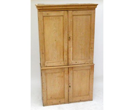 A late 19th century pine cupboard, the upper section with two panel doors enclosing four adjustable shelves above a base of t