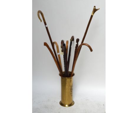 A group of five various walking sticks including gnarled examples, an ebonised example and an example with African figural fi