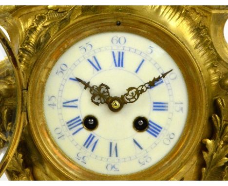 A large decorative c.1900 French gilt metal mantel clock, the rococo scrolling case centred with a circular dial set with blu