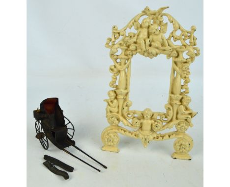 A c.1900 tinplate model of a rickshaw with chinoiserie decoration (af) and a cast iron frame decorated with cherubs and scrol