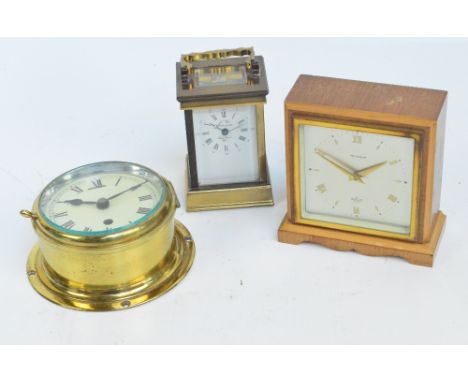 An early 20th century French brass cased carriage clock with swing loop handle and rectangular enamel dial set with Roman num