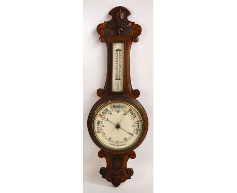A 1920s carved oak banjo aneroid barometer/thermometer, height 76cm.