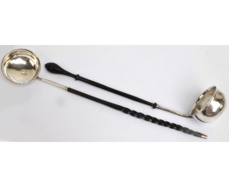 A Georgian white metal toddy ladle of plain oval form with flared rim and tapering stem with turned wooden handle, set with S