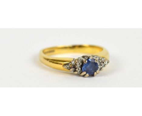 An 18ct yellow gold and sapphire ring, the central heart shaped faceted stone flanked with six tiny diamonds to each side, si