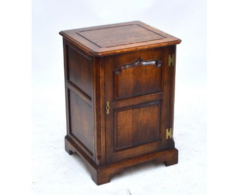 A reproduction oak pot cupboard with fielded panel door, width 53cm.