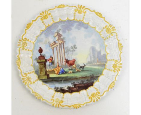 An 18th century Battersea enamelled plate, the central circular panel decorated with a capriccio of figures and animals besid