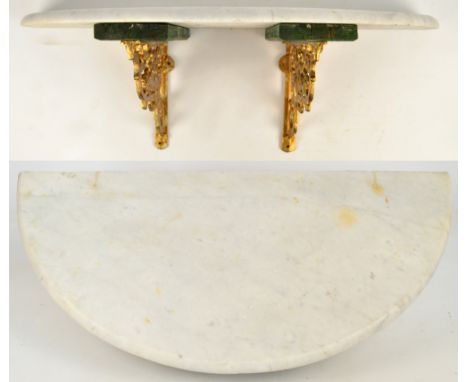 A white marble demi-lune shelf mounted on twin gilt metal pierced scrolling brackets, width 85cm.