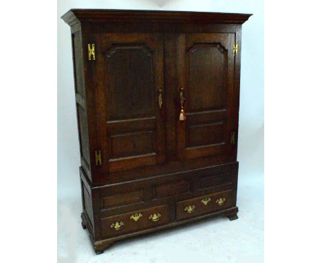 A Georgian oak livery cupboard, with pair of panel doors enclosing handing space above two base drawers, width 152cm. CONDITI