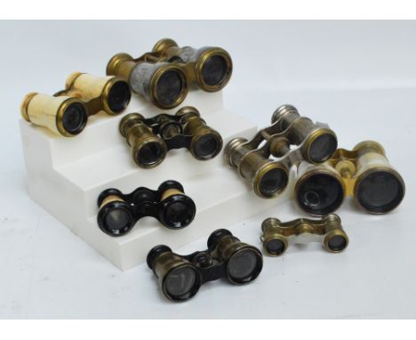 A collection of various opera glasses including a bone covered pair, a mother of pearl pair, a brass and pewter pair inscribe