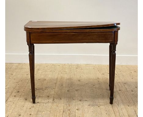 An early 19th century mahogany card table, the fold over revolving top opening to a baize lined playing surface, over a boxwo