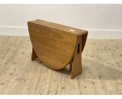 Ercol, a blonde elm drop leaf table, the oval top on pierced and shaped panel end supports, H46cm, W70cm, L106cm