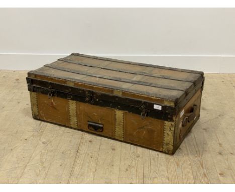 An early 20th century tooled leather and wooden bound steamer trunk, with leather carry handle to each end and paper lined in
