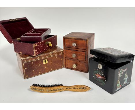 A Japanese black lacquered tea caddy with painted figures and fish (13cm x 13cm), a treen nest of three drawers with fabric k