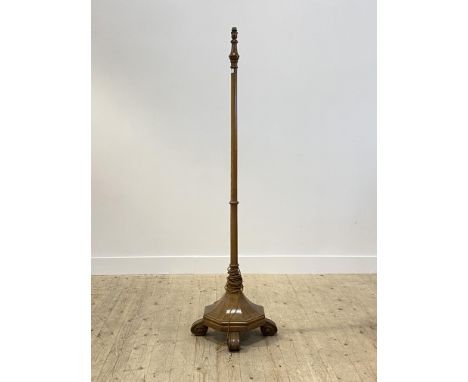 An early 20th century oak lamp standard, the ring turned column on a faceted octagonal base with four scrolled supports, H171