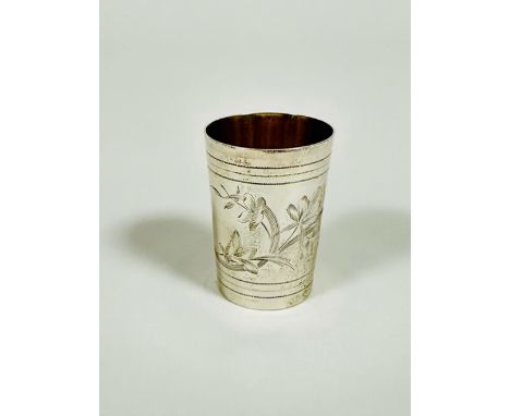 A Russian silver vodka shot glass in the Edwardian style, of tapered cylinder form, with engraved leaf and floral spray, with