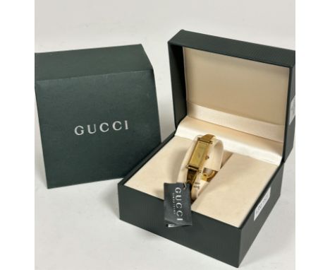 A Gucci gilt on stainless steel lady's quartz wristwatch with rectangular dial on metal stiff bangle with horse bit clasp fas