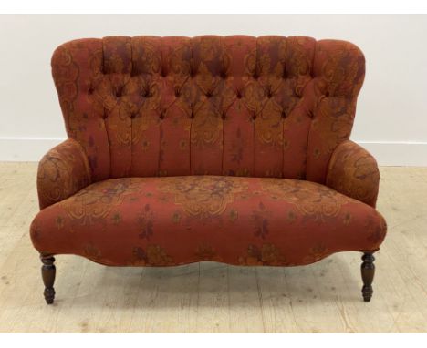 A Victorian style two seat sofa, possibly Derwent, upholstered in a deep red floral and buttoned fabric, raised on turned fro