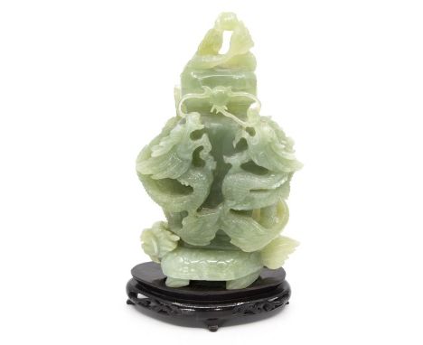 A Chinese green turtle-dragon jade vase and cover, carved and pierced with dragons, 20th century, on pierced wood stand, 18.5