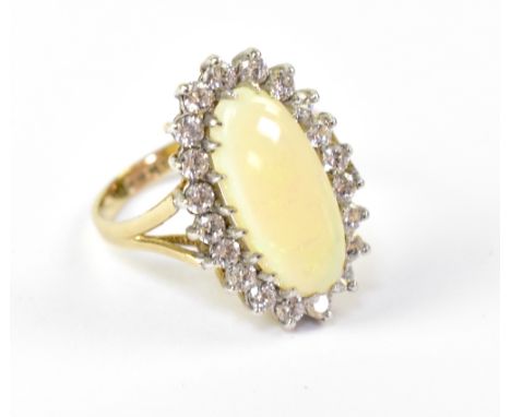 A 9ct yellow gold dress ring with large oval opal with white stone surround, size K, approx 2.7g. 