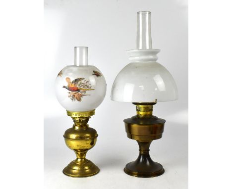 A brass oil lamp with opaque globular shade decorated with pheasants in flight, height 46cm and a similar undecorated example