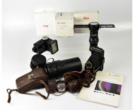 A collection of camera accessories including a partial leather Leica case, a Leica advertising brochure, a Kodak folding Brow