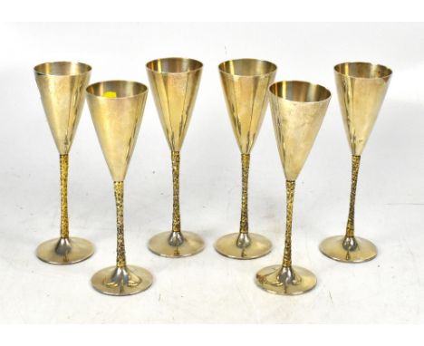 STUART DEVLIN (1931-2018); a set of six hallmarked silver wine goblets, the bowl of conical form on naturalistic stem, each w