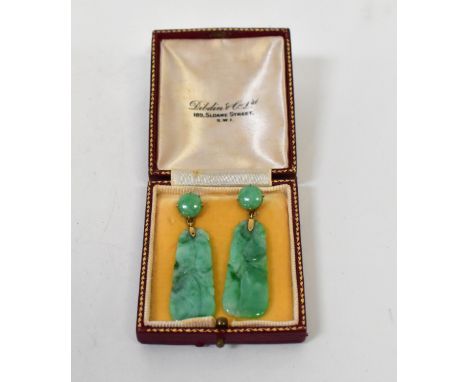 A pair of vintage jade-style earrings with carved tablet-style drops suspended under claw set round cabochon, on yellow metal