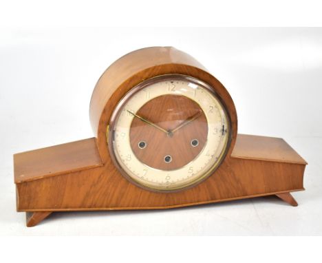 A Smiths pale oak Art Deco style duel chime mantel clock with outswept supports, the wooden and cream dial set with Arabic nu