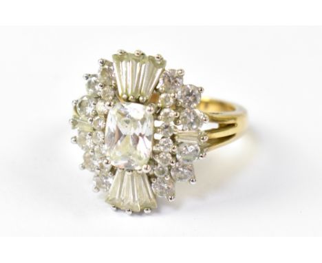 A 9ct yellow gold dress ring in the Art Deco style, set with central emerald cut white stone and baguette and round white sto