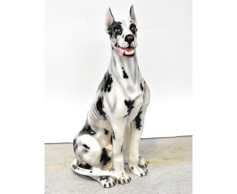A large near life sized ceramic figure of a seated Great Dane, black and white body, height 104cm.