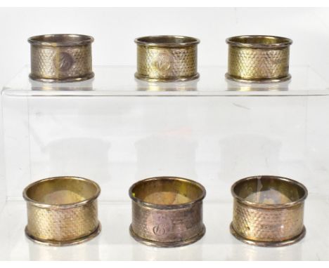 A set of six Edwardian hallmarked silver napkin rings, with engine turned central band, with initial 'P' within a circle, rai